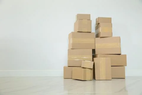 Stack of cardboard boxes for moving, Empty room with a white wall and cardboa Foto stock