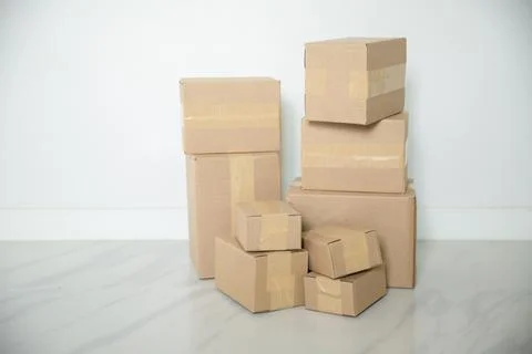 Stack of cardboard boxes for moving, Empty room with a white wall and cardboa Stock Photos