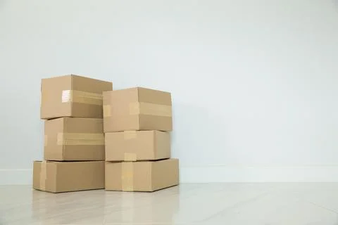 Stack of cardboard boxes for moving, Empty room with a white wall and cardboa Foto stock