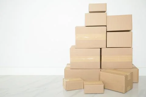 Stack of cardboard boxes for moving, Empty room with a white wall and cardboa Stock Photos