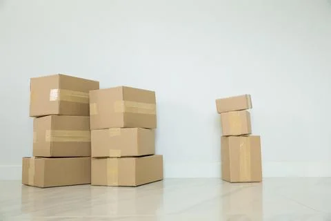 Stack of cardboard boxes for moving, Empty room with a white wall and cardboa Stock Photos