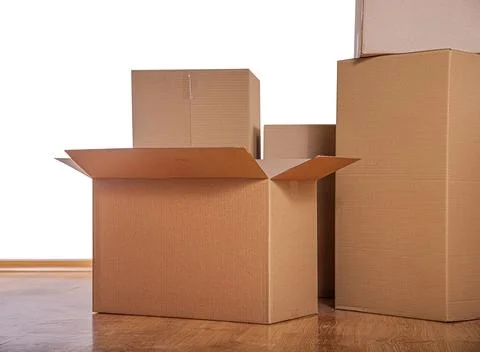 Stack of cardboard boxes on a wooden floor against a white background 스톡 사진