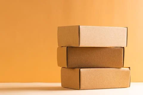 Stack of cardboard gift boxes with copy space over yellow background Foto stock
