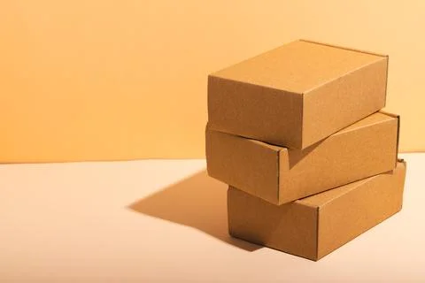 Stack of cardboard gift boxes with copy space over yellow background Foto stock