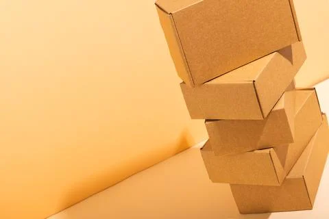 Stack of cardboard gift boxes with copy space over yellow background Stock Photos