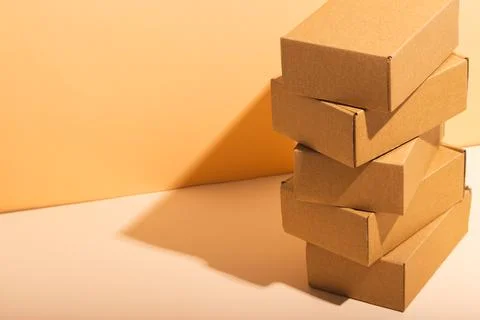 Stack of cardboard gift boxes with copy space over yellow background Stock Photos