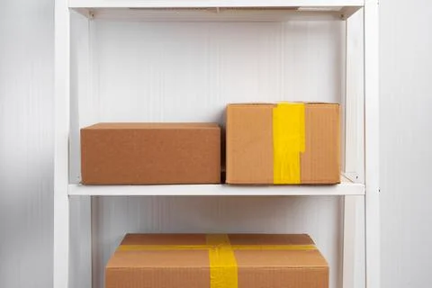 Stack of cardboard package boxes on wooden rack Stock Photos