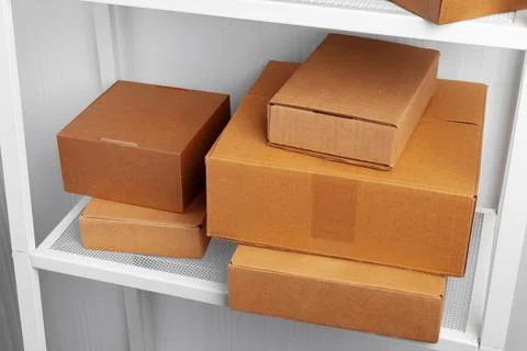 Stack of cardboard package boxes on wooden rack Stock Photos