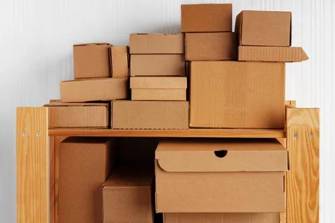 Stack of cardboard package boxes on wooden rack Stock Photos