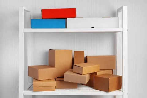 Stack of cardboard package boxes on wooden rack Stock Photos
