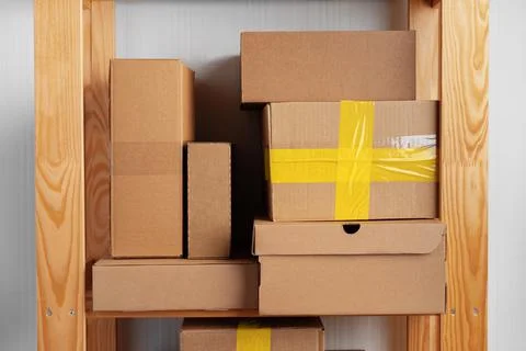 Stack of cardboard package boxes on wooden rack Stock Photos