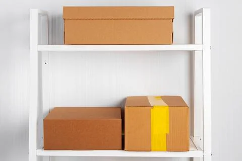 Stack of cardboard package boxes on wooden rack Stock Photos