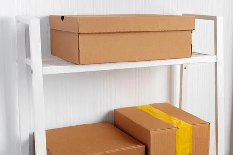 Stack of cardboard package boxes on wooden rack Stock Photos