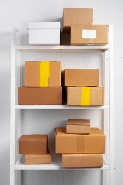 Stack of cardboard package boxes on wooden rack Stock Photos