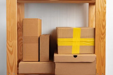 Stack of cardboard package boxes on wooden rack Stock Photos