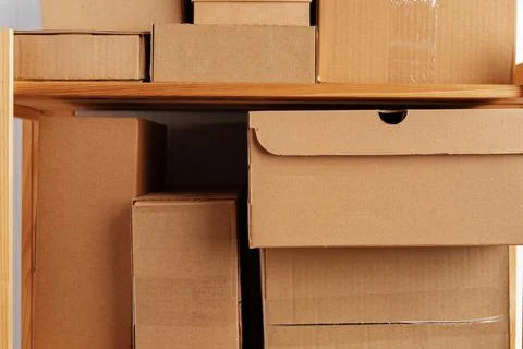 Stack of cardboard package boxes on wooden rack Stock Photos