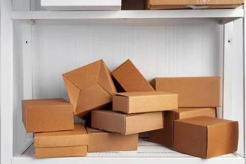 Stack of cardboard package boxes on wooden rack Stock Photos