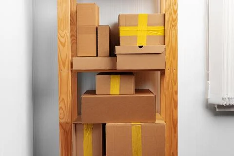 Stack of cardboard package boxes on wooden rack Stock Photos