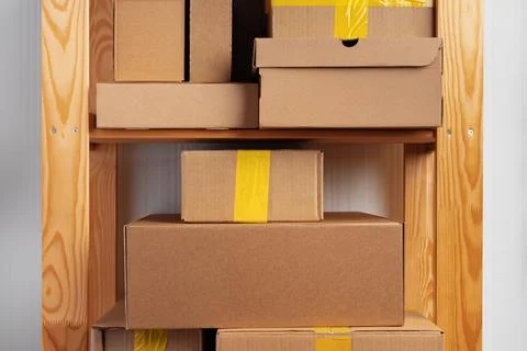 Stack of cardboard package boxes on wooden rack Stock Photos