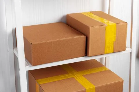Stack of cardboard package boxes on wooden rack Stock Photos