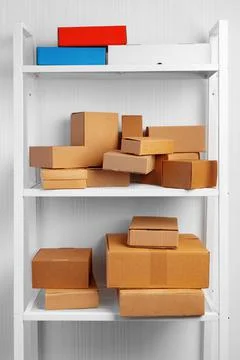 Stack of cardboard package boxes on wooden rack Stock Photos