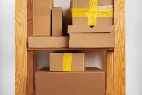 Stack of cardboard package boxes on wooden rack Stock Photos