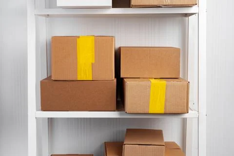 Stack of cardboard package boxes on wooden rack Stock Photos
