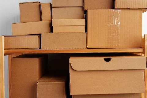 Stack of cardboard package boxes on wooden rack Stock Photos