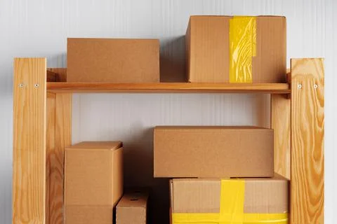 Stack of cardboard package boxes on wooden rack Stock Photos