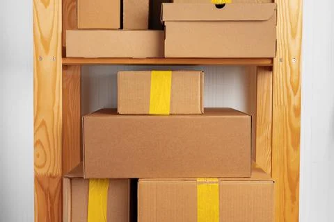 Stack of cardboard package boxes on wooden rack Stock Photos