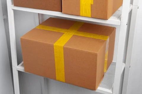 Stack of cardboard package boxes on wooden rack Stock Photos