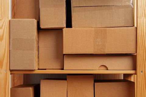 Stack of cardboard package boxes on wooden rack Stock Photos