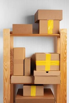 Stack of cardboard package boxes on wooden rack Stock Photos
