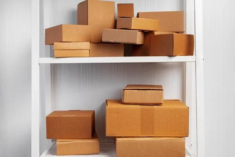Stack of cardboard package boxes on wooden rack Stock Photos