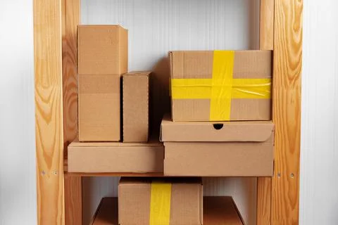 Stack of cardboard package boxes on wooden rack Stock Photos