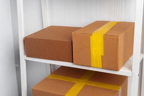 Stack of cardboard package boxes on wooden rack Stock Photos