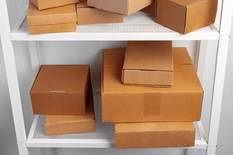 Stack of cardboard package boxes on wooden rack Stock Photos
