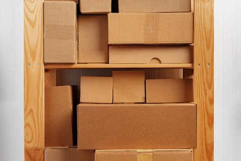 Stack of cardboard package boxes on wooden rack Stock Photos