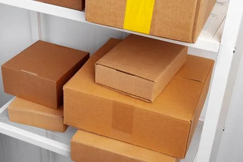 Stack of cardboard package boxes on wooden rack Stock Photos