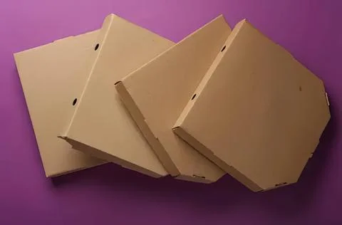Stack of cardboard pizza boxes on purple background Stock Photos