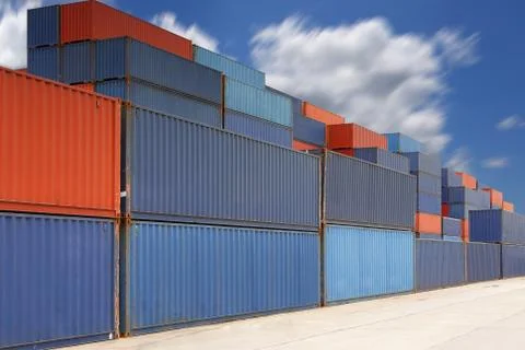 Stack of cargo containers at container yard with cloud Stock-Fotos