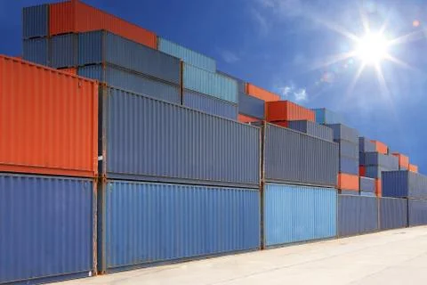 Stack of cargo containers at container yard with sunbeam Stock Photos