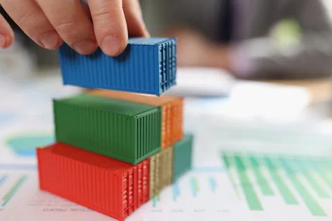 Stack of cargo containers on financial report papers and blurred business man. Stock Photos