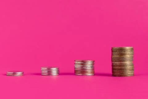 Stack of cash coins showing increase graph on color surface Stock Photos
