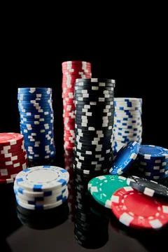 Stack of Casino gambling chips isolated on black reflective background Photos