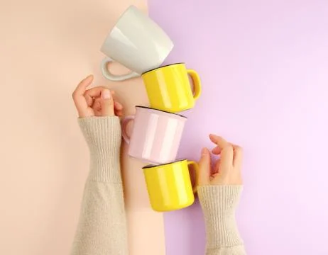 Stack ceramic cups are supported by a female hand Stock Photos