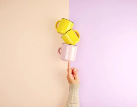 Stack ceramic cups are supported by a female hand Stock Photos