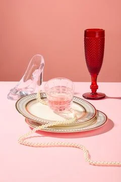 A stack of ceramic dish with a cup of pink liquid placed on top. Red wine gla Stock Photos