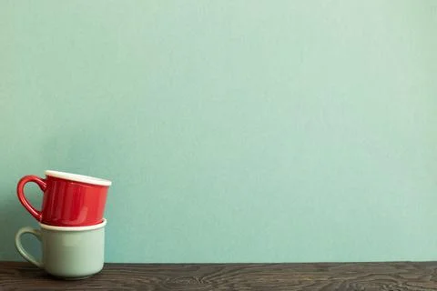 Stack of ceramic mug cups on wooden table. green background Stock Photos