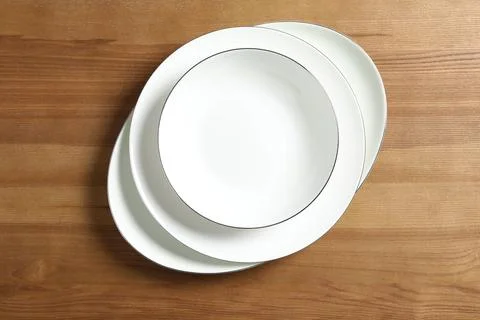 Stack of ceramic plates on wooden table, top view 写真素材